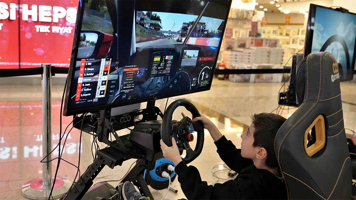 Direksiyon setiyle araba yarışı simülasyonu oynayan bir çocuk çok eğleniyor