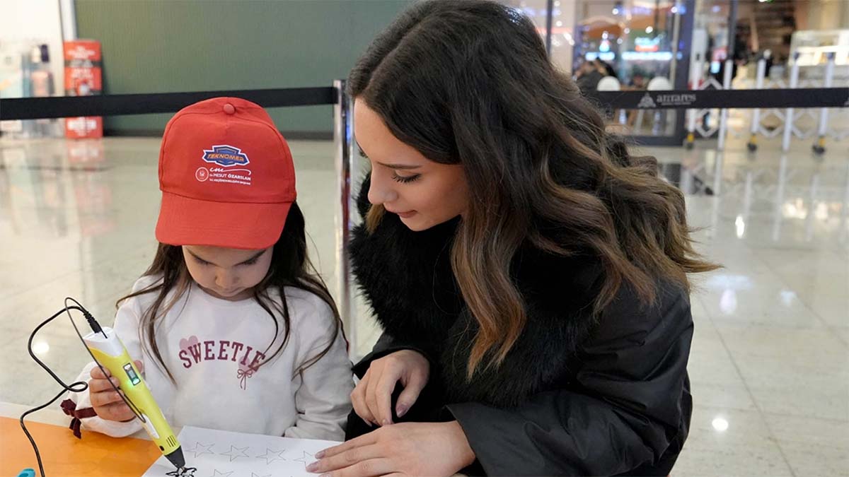 Bir Öğretmen minik bir öğrenciyle inovatif yıldız boyama çalışması yapıyor.